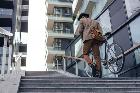 Young handsome man with business suit driving bicicyle to go to office - Corporate businessman portrait biking in the city, concepts about business, green mobility and lifestyle