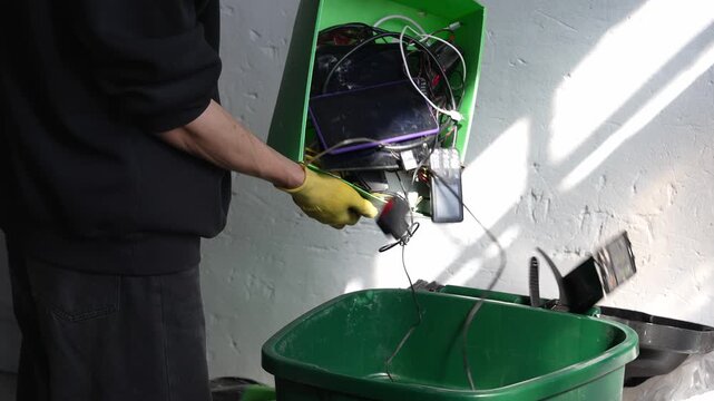 Person disposing electronic waste in garbage overconsumption theme