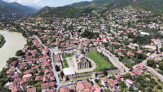 Aerial drone approach to Svetitskhoveli Cathedral in ancient Mtskheta, Georgia, revealing the historic UNESCO World Heritage landmark and spiritual center of the Georgian Orthodox Church