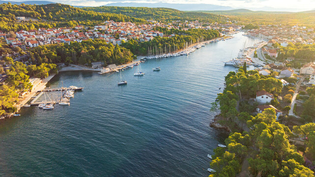 High angle drone shot displays stunning coastal landscape of Hvar Island. Panorama includes historic Stari Grad port