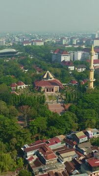 Aerial Yogyakarta mosque with tall minaret amid lush city greenery