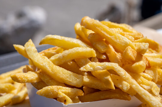 Fish and chips on Le Treport promenade &mdash; golden battered cod with mountain of french fries, seaside flavors enjoyed outdoors by the harbor in Normandy, France