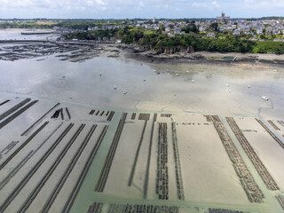 Aerial drone view of underwater oyster farms in Cancale, Brittany, exposed during low tide, raditional sustainable aquaculture and production of premium French oysters, France © barmalini