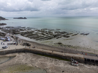 Aerial drone view of underwater oyster farms in Cancale, Brittany, exposed during low tide, raditional sustainable aquaculture and production of premium French oysters, France © barmalini