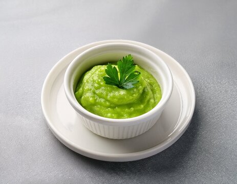aromatic green pea puree with fresh parsley garnish served in a small white bowl on a plate