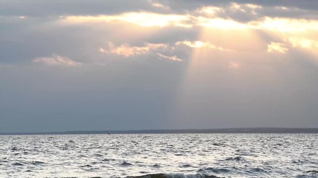sunset background on bay with sun rays through clouds