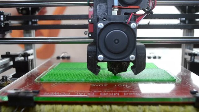 3D printer printing green model. Object printed on 3D printer from molten plastic green color. 3D printed object made from molten green plastic. Additive modern manufacturing. 3D printing technology