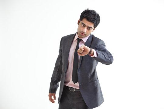 Busy businessman checking time over white background 