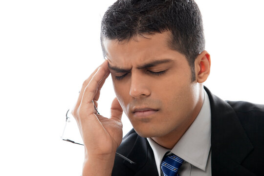 Close-up of businessman with headache over white background 