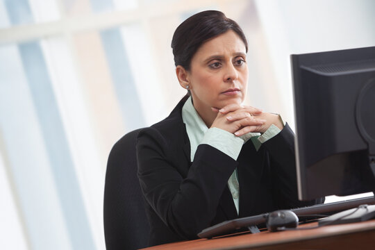 Mature businesswoman looking at computer with concentration 
