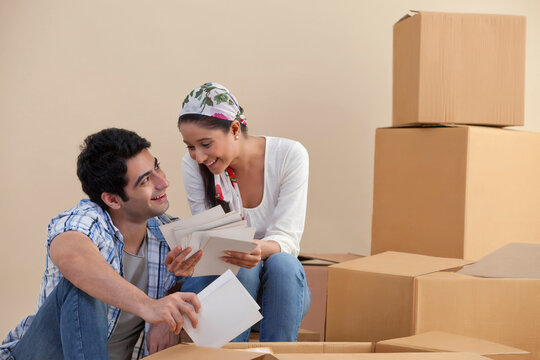 Young couple smiling while looking at photographs 