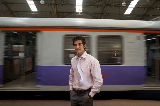 Businessman standing next to a train compartment 