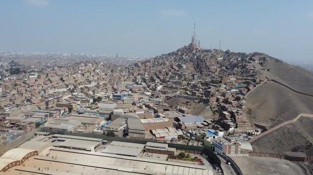 Aerial view flying towards the crowded shanty town on cerro la milla in san martin de porres, lima