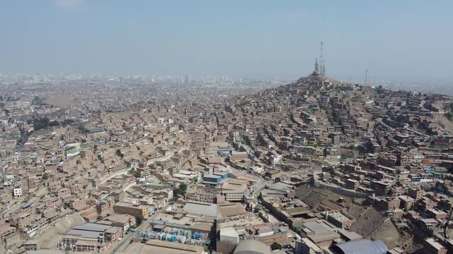 Overpopulated hillside shantytown slum in san martin de porres district under a hazy sky