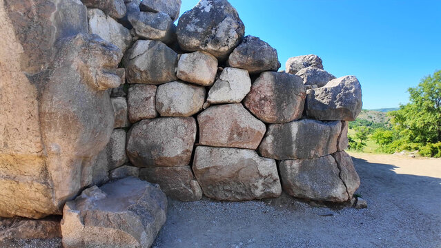 Ancient stone lion sculpture carved into massive cyclopean stone walls at the Lion Gate of Hattusa in Boğazkale, Turkey.