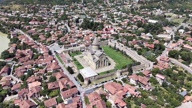 Slow aerial orbit around Svetitskhoveli Cathedral in Mtskheta, Georgia, revealing its medieval architecture, fortified walls and historic old town from a cinematic drone perspective