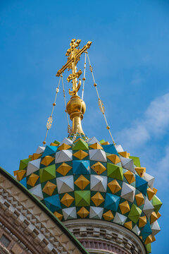 Ornate patterned dome of Church of the Savior on Blood with golden cross and copy space