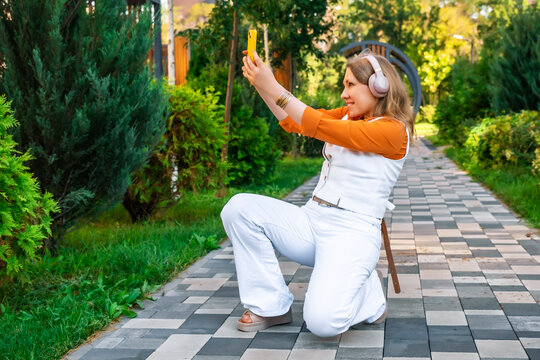 Woman making smartphone video call in summer park. Concept of modern online communication.