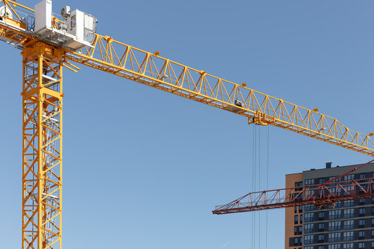 Tower crane arm extending over a residential construction site. Yellow crane structure captured