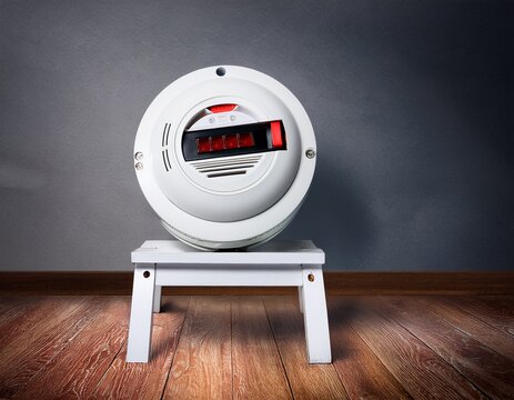 open smoke detector with fresh battery on step stool