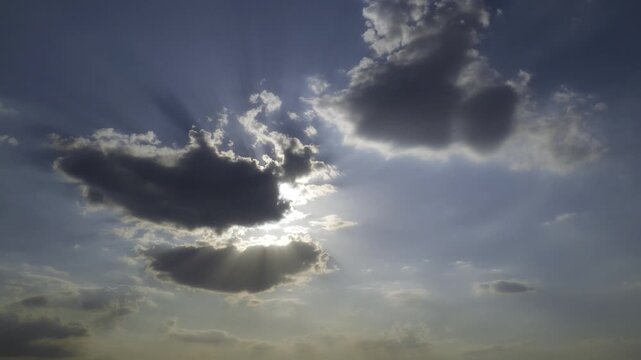Dramatic Sun Rays Bursting Through Dark Clouds in Blue Sky.
Dramatic clouds partially obscure the sun as brilliant rays of sunlight burst through gaps in the clouds.