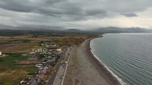 Aerial Video Dinas Dinille Beach Wales.The cliff above the beach is known as Boncan Dinas and is occupied by an Iron Age hillfort, Dinas Dinlle itself. This fort has been eroded by the sea.