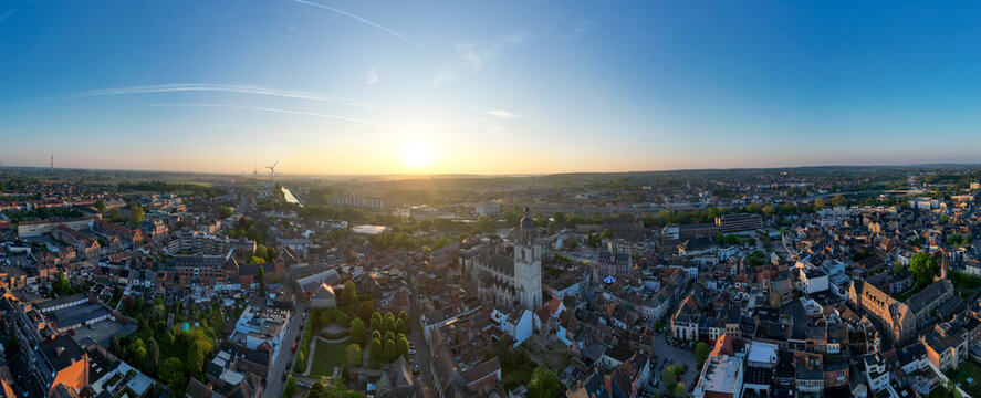 Halle, Vlaams Brabant, Belgium, 27th of April, 2025, A stunning panoramic view showcasing a vibrant cityscape at sunset, featuring beautiful buildings and lush green spaces