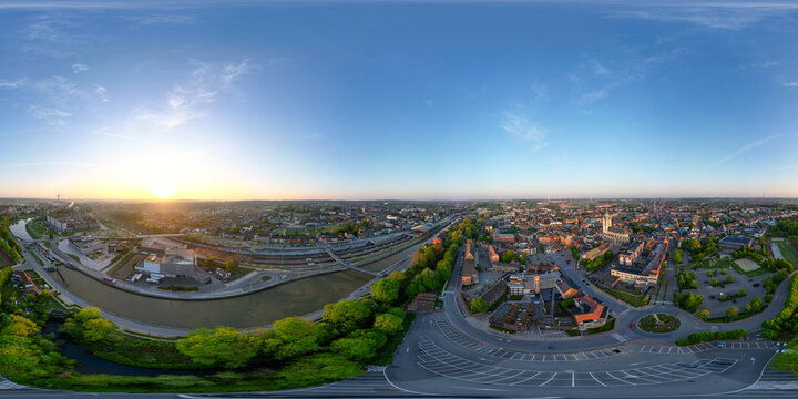 Halle, Vlaams Brabant, Belgium, 27th of April, 2025, A stunning aerial view of a vibrant city at sunrise, highlighting the beauty of urban life and nature