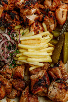 Grilled meat platter with pork and chicken shish kebab and french fries