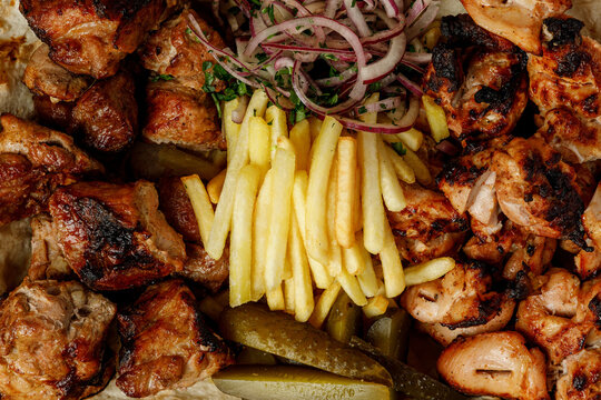 Grilled meat platter with pork and chicken shish kebab and french fries