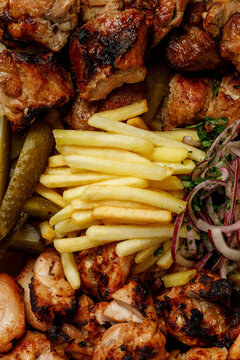 Grilled meat platter with pork and chicken shish kebab and french fries