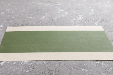 Fototapeta premium Perspective view of green tablecloth for food on cement background. Empty space for your design