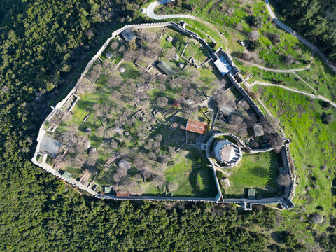 Aerial view of Platamon Castle showing the medieval fortress walls, central tower, and surrounding green landscape in Platamon Castle, Greece.