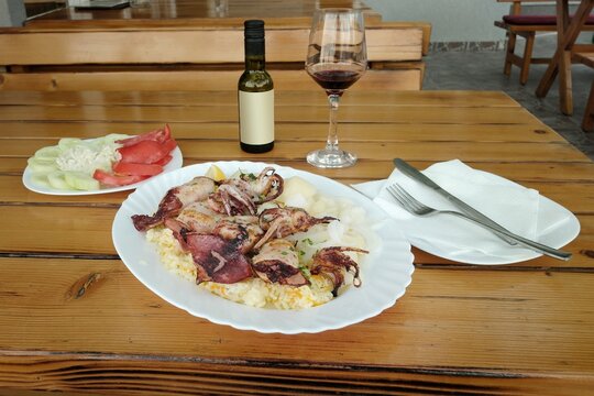 a dish of grilled squid with rice, potatoes and mixed salad in a restaurant along the coast of Montenegro