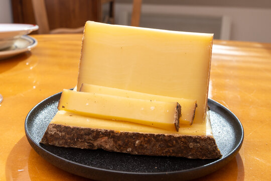 Comte hard french cheese from France's Jura Mountains made from unpasteurized cow's milk with traditional methods in cooperative dairies with nutty flavor, creamy texture, aged in natural caves