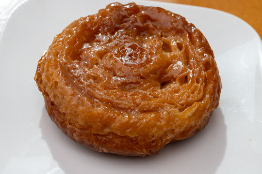 Kouign-amann legendary Breton confection from Douarnenez,  Saint-Malo, Brittany with butter, sugar, puff dough, crispy caramelized layers, authentic French pastry with centuries-old tradition