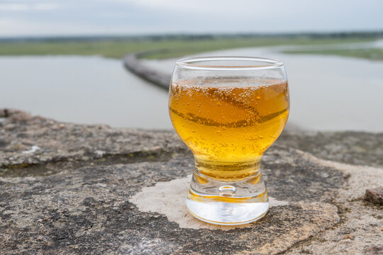 Normandy cider poured on fortress walls of Mont-Saint-Michel stunning abbey hill in ocean, sparkling apple beverage, refreshing taste. France