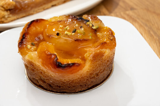 Brittany artisan bakery apricot tart with thinly sliced, caramelized apricots on buttery pastry with glossy glaze; sweet, French breakfast in bakery