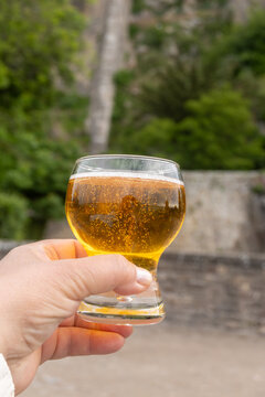 Normandy cider poured on fortress walls of Mont-Saint-Michel stunning abbey hill in ocean, sparkling apple beverage, refreshing taste. France