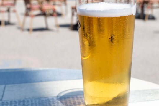 Artisanal craft beers on wooden deck in outdoor cafe, near ocean at Mers-les-Bains, Normandy, golden pale ale served at beachfront bar with Atlantic waves in the background