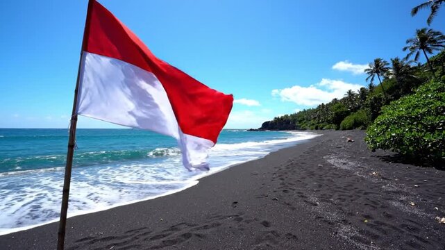 Indonesian flag waving on a tropical black sand beach