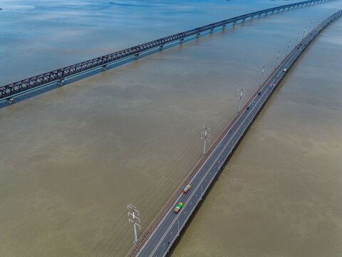 Aerial view of Jamuna Bridge spanning the Jamuna River with vehicles traveling on the road and a parallel railway track in Tangail District, Dhaka Division, Bangladesh.