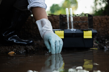 Environmental engineer collecting water quality assessment for detecting toxic chemical contamination in an irrigation canal. © sawitreelyaon