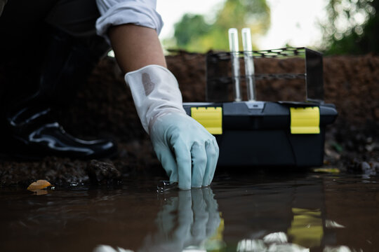 Environmental engineer collecting water quality assessment for detecting toxic chemical contamination in an irrigation canal.