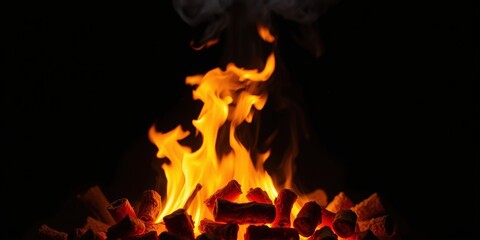 Fototapeta premium A fiery blaze dances atop a pile of burning fuel, casting a warm glow against the stark darkness.