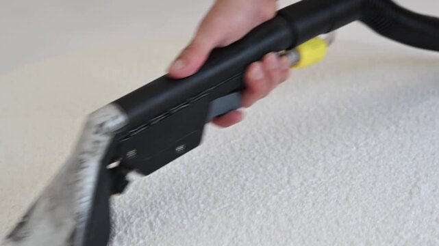 Deep extraction cleaning of white boucle fabric chair using professional vacuum tool. modern wet-and-dry vacuum cleaner	