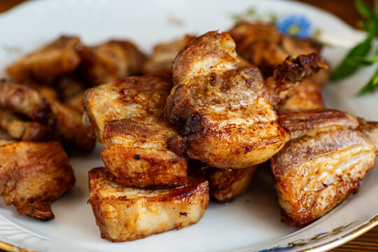 Juicy roasted pork meat served on ceramic plate with dark background