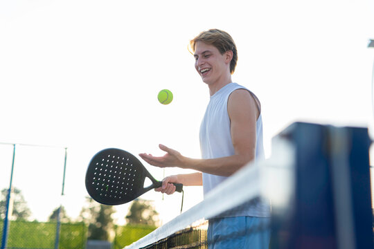 Young man playing padel tennis on outdoor court