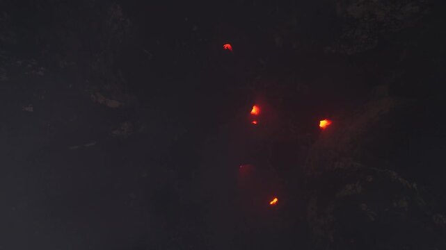 Incredible drone footage flying inside the active crater of Mount Yasur volcano, Tanna, Vanuatu. View of small spots of violent red glowing lava. Smoking caldera in extreme geological environment.