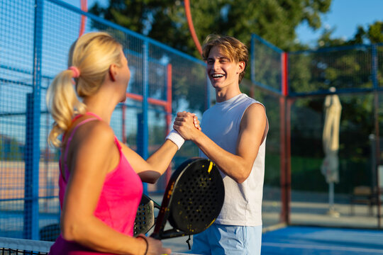 Padel players shaking hands celebrating victory on court